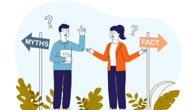Illustration of two people standing between directional signs labeled “MYTHS” (left) and “FACT” (right). One person wears a blue shirt and dark pants, holding a book and raising a hand; the other wears an orange jacket over a white top with dark pants, gesturing with open hands. Question marks appear above their heads, with green plants at the bottom.